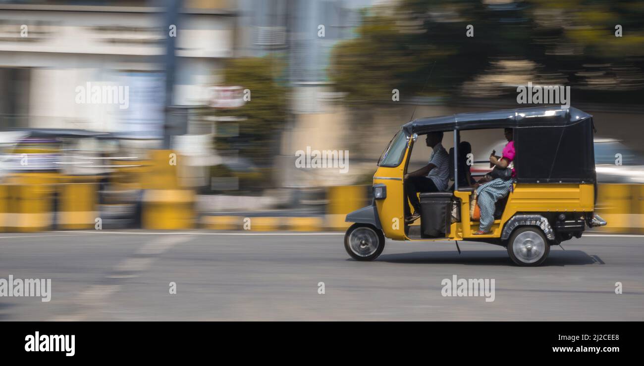 An auto rickshaw on roads of Indian city on a sunny day - long exposure ...