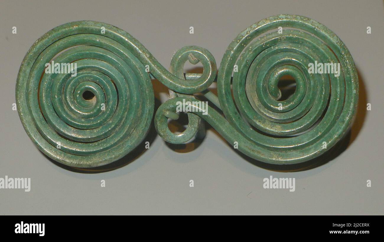 Worn as a clasp for clothing, this type of double-spiral fibula was popular in Greece before the style was adopted in the southern Italian peninsula. Stock Photo