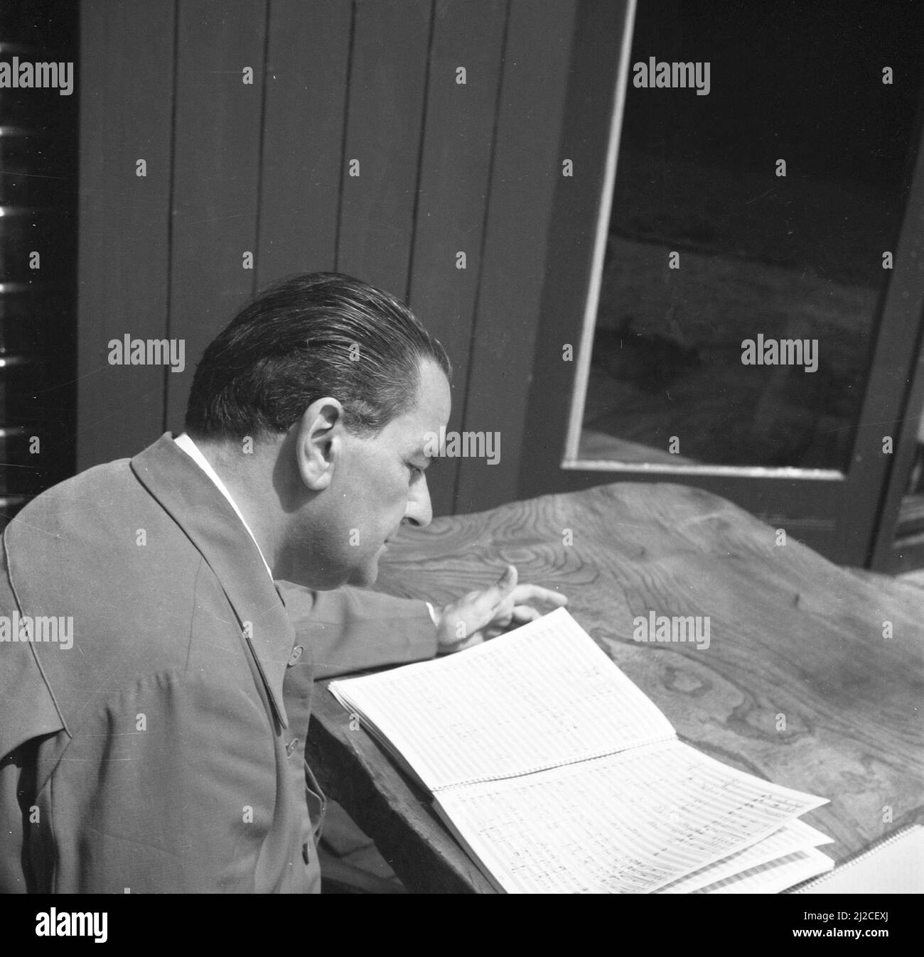 The conductor Eduard van Beinum studies a score at a table on the terrace  of his country house in Garderen ca: June 5, 1954 Stock Photo - Alamy