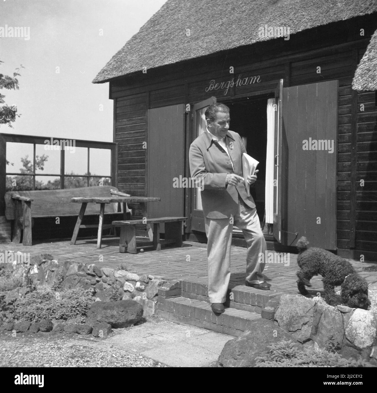 The conductor Eduard van Beinum walks on the terrace with his dog David at  his country house in Garderen ca: June 5, 1954 Stock Photo - Alamy