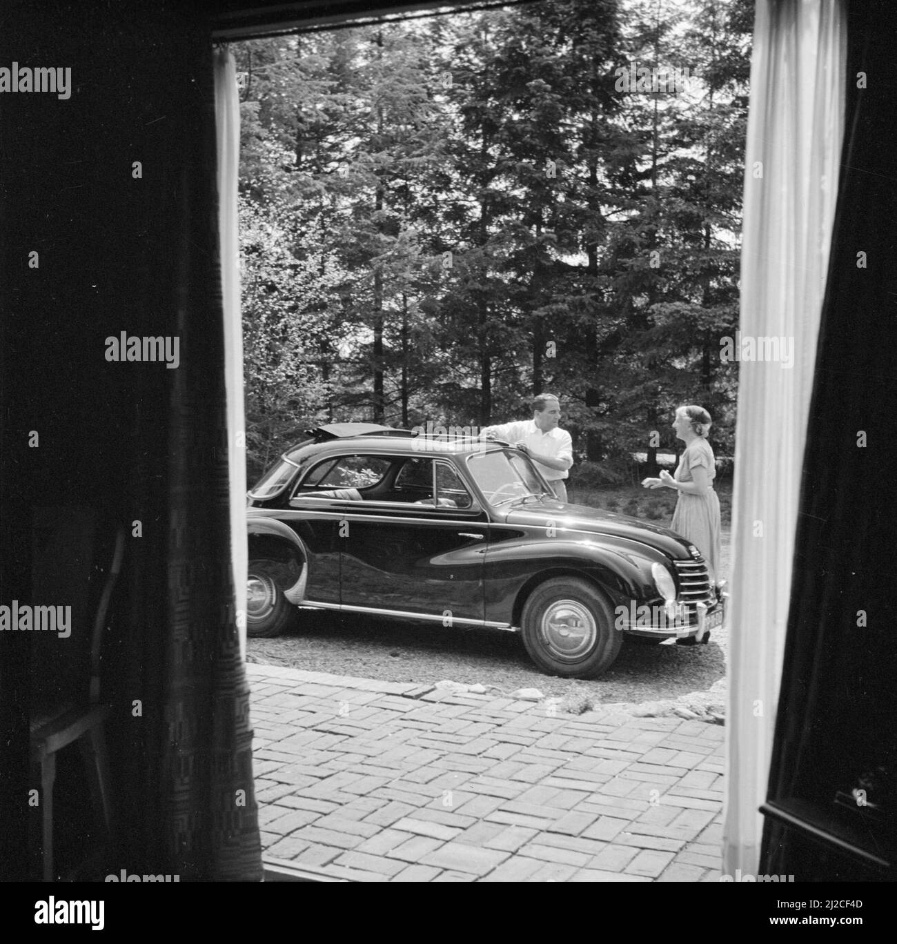 The conductor Eduard van Beinum stands with his wife Sepha van Beinum-Janssen at their open DKW at their country house Bergsham in Garderen ca: June 5, 1954 Stock Photo