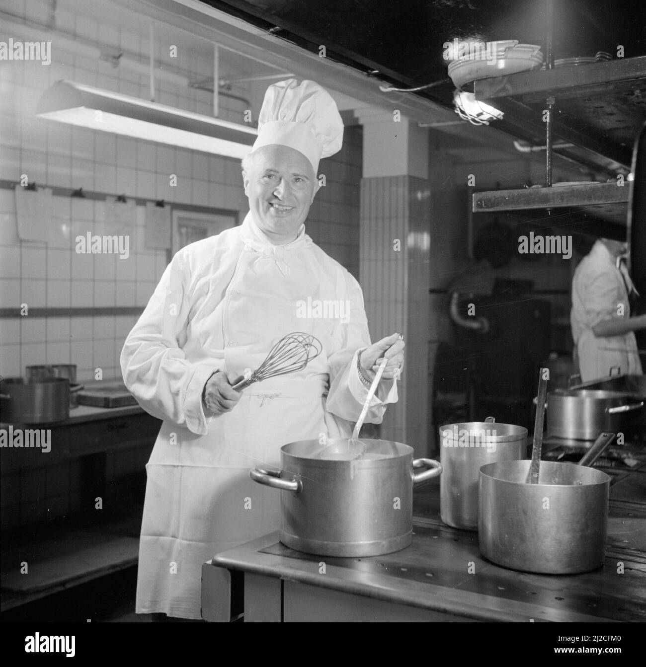1950s chef cooking food in a large kitchen ca: June 26, 1954 Stock Photo
