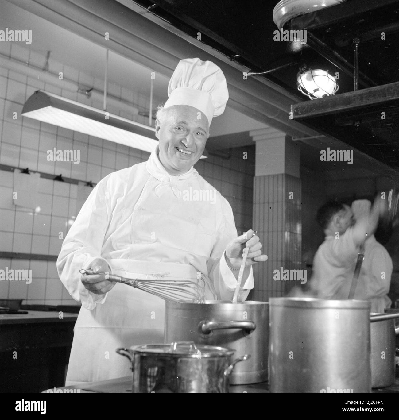 1950s chef cooking food in a large kitchen ca: June 26, 1954 Stock Photo