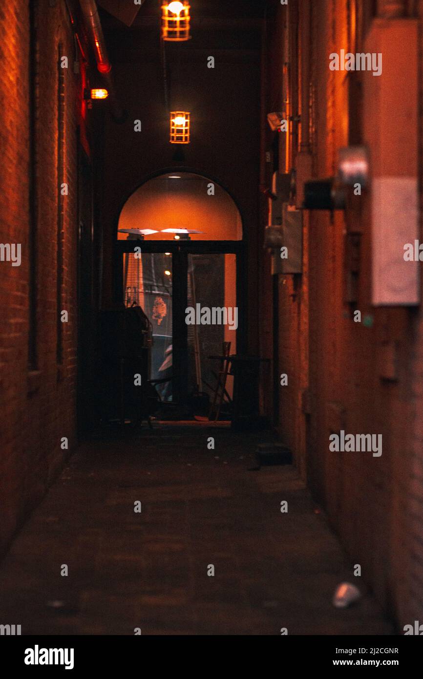 A vertical shot of an illuminated orange alley in Gainesville, Florida Stock Photo