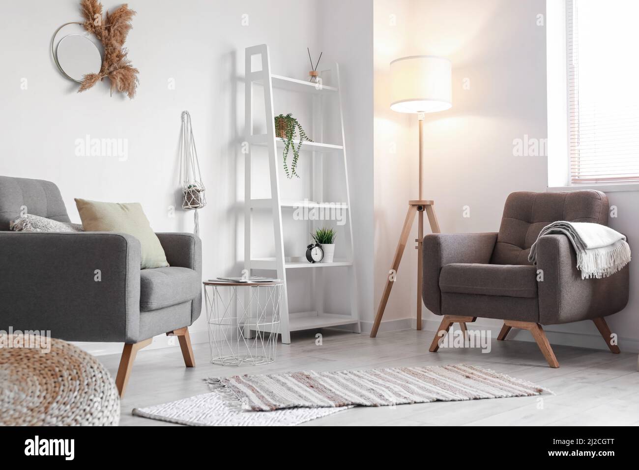 Interior of modern living room with comfortable armchairs and shelving
