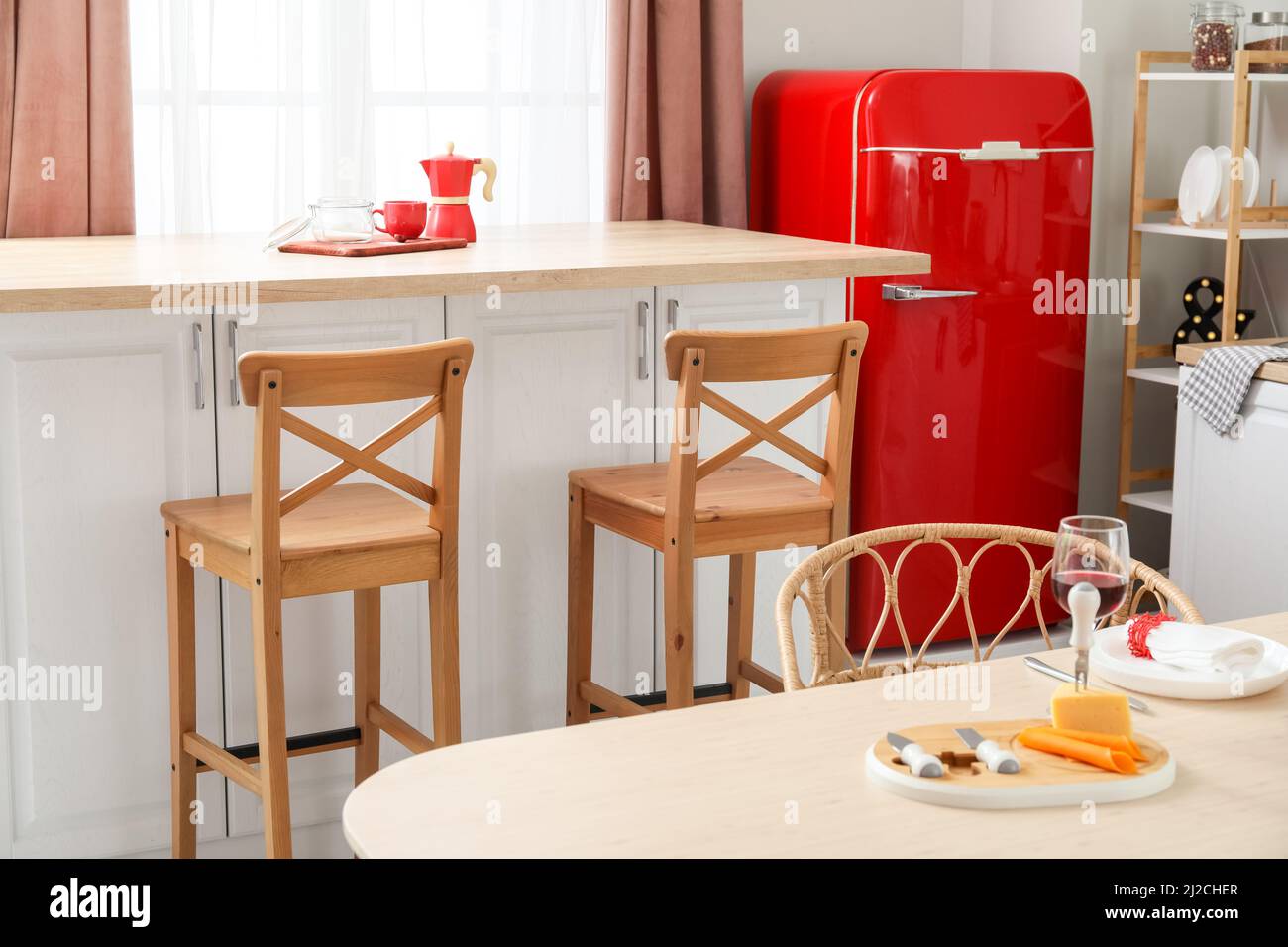 Interior of light kitchen with retro fridge, white counters and chairs ...