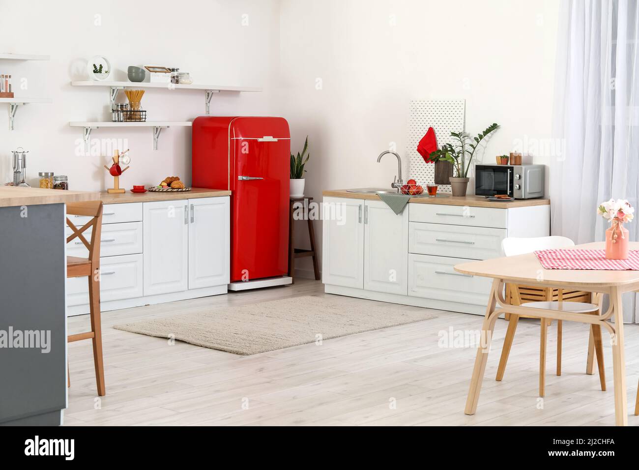 Interior of light kitchen with red fridge, counters and shelves Stock ...