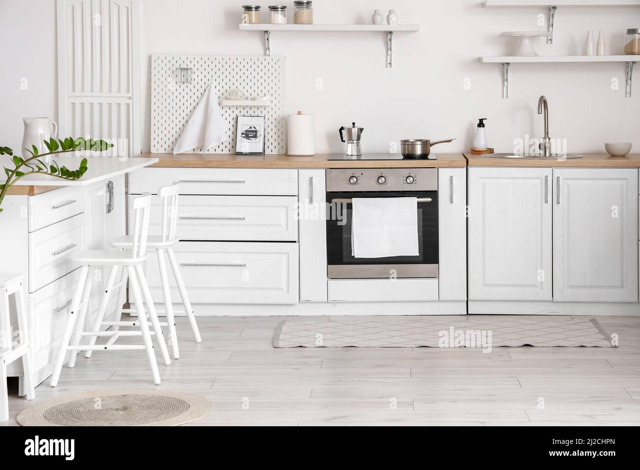 Stylish interior of light kitchen with counters and chairs Stock Photo ...