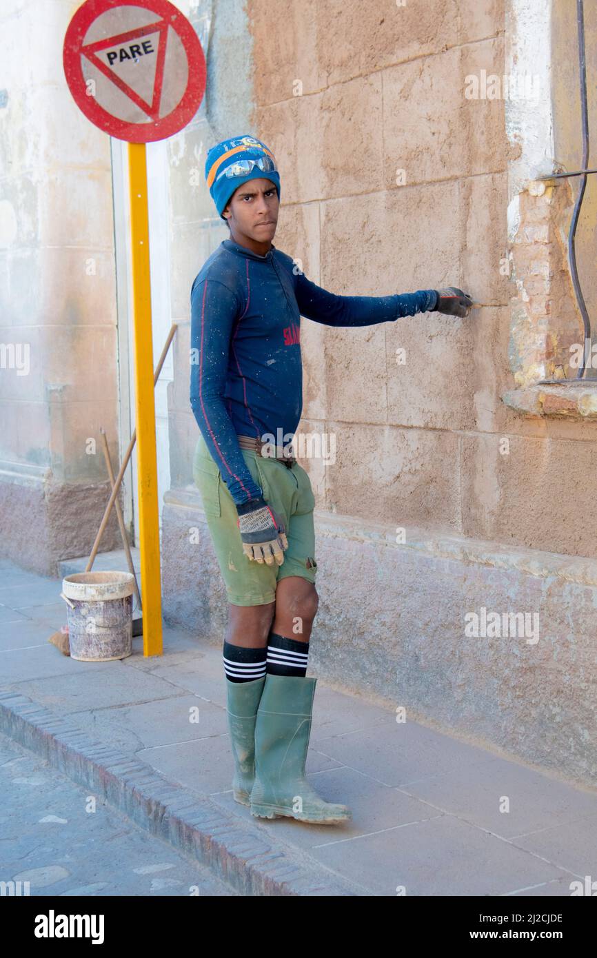 Young construction worker leans against a building in Trinidad, Cuba a Unesco World Heritage Site. Stock Photo