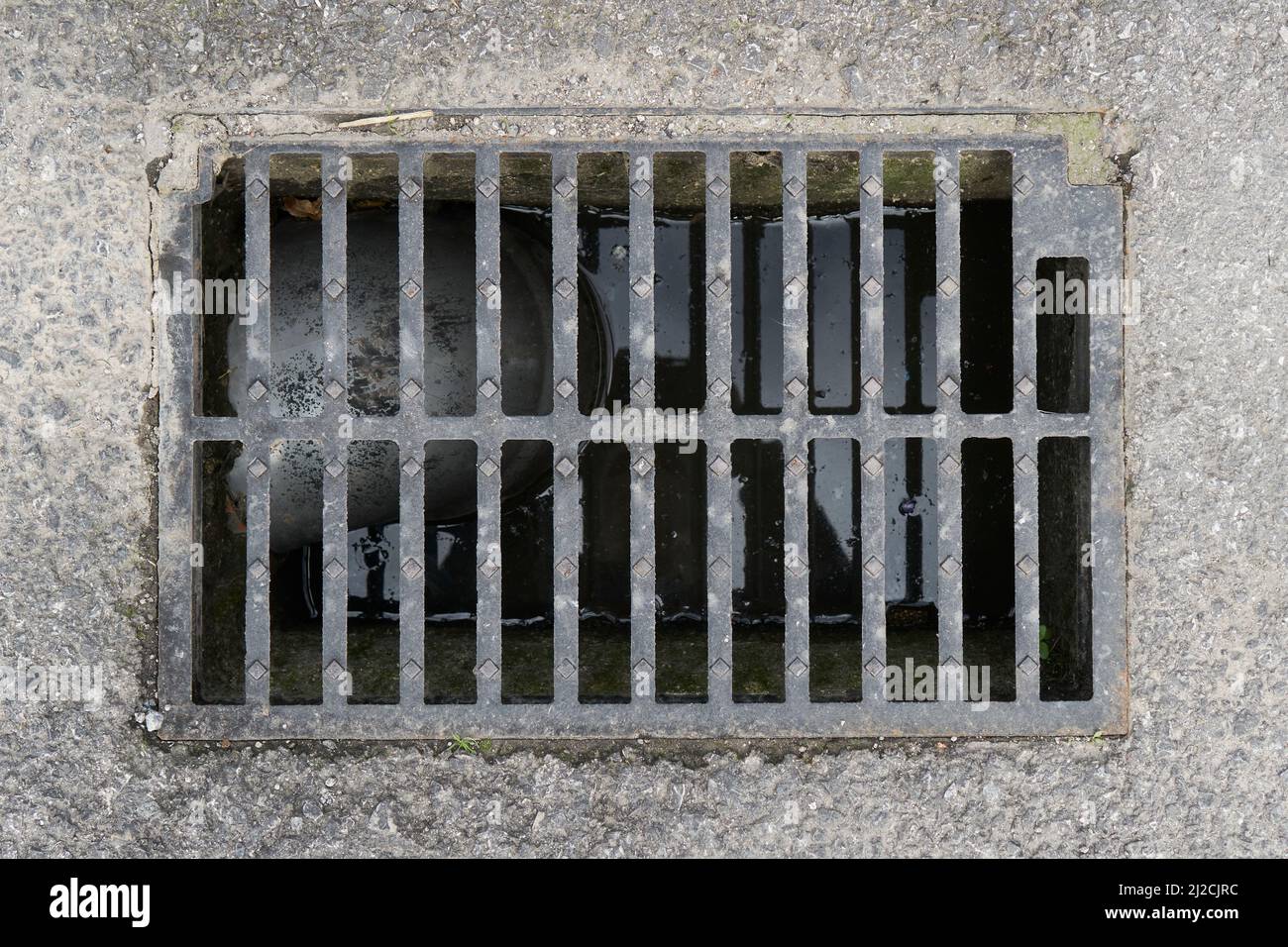 Drainage sewer grate with water level inside and plastic pipe. On an