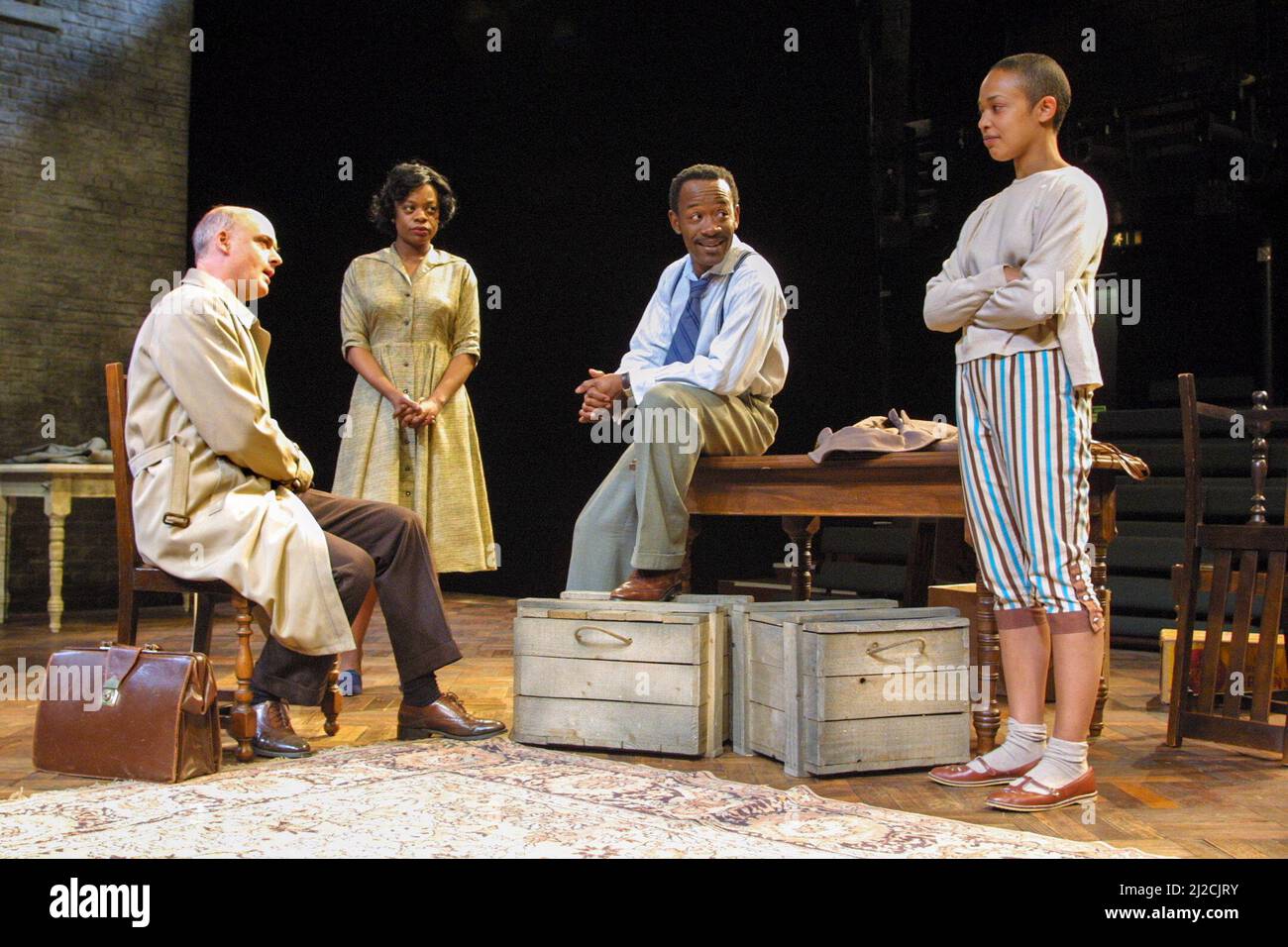 l-r: William Chubb (Karl Lindner), Cecilia Noble (Ruth Younger), Lennie James (Walter Lee Younger), Kananu Kirimi (Beneatha Younger) in A RAISIN IN THE SUN by Lorraine Hansberry at the Young Vic Theatre, London SE1  04/06/2001               design: Francis O’Connor  lighting: Tim Mitchell  director: David Lan Stock Photo