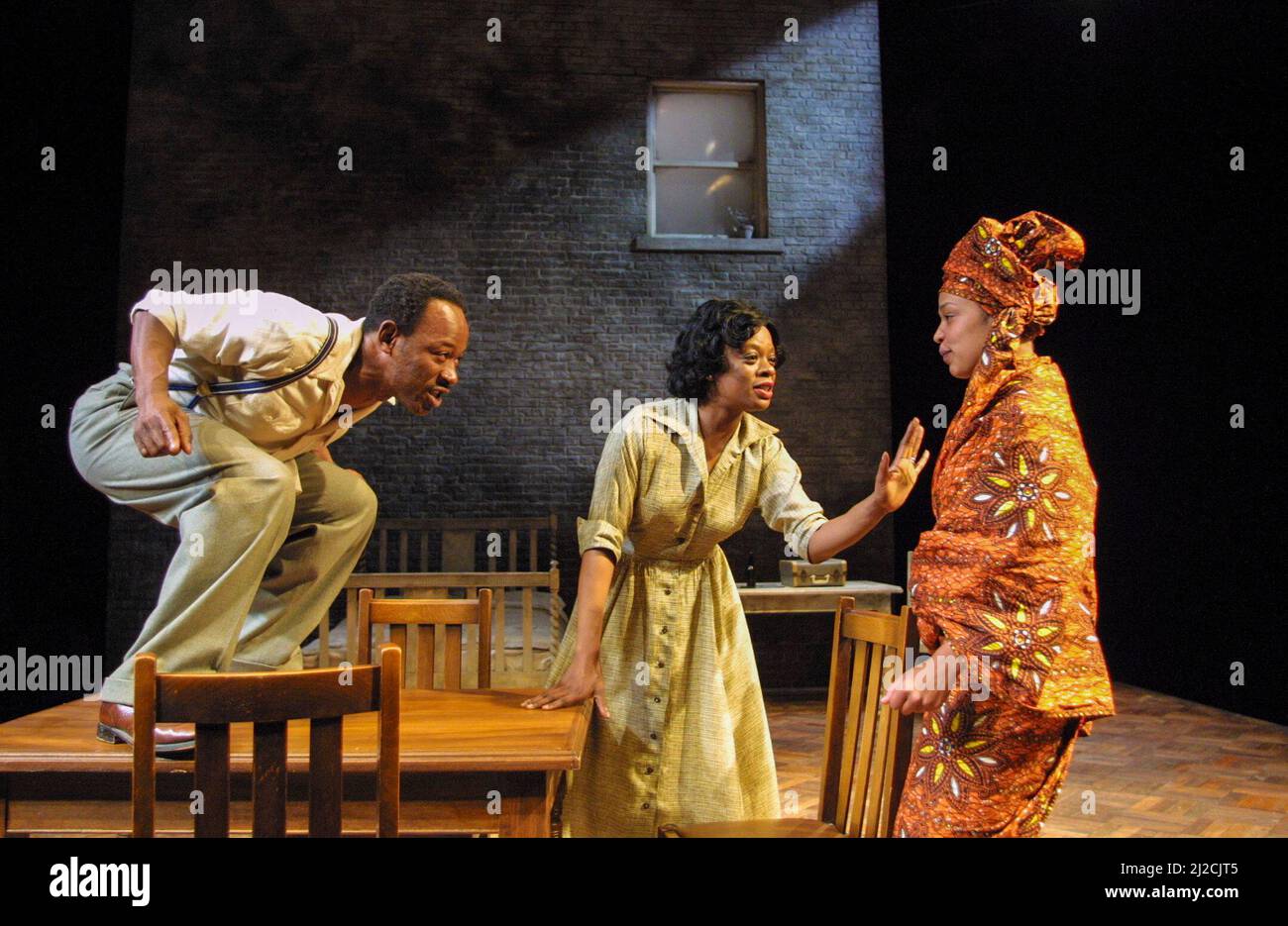 l-r: Lennie James (Walter Lee Younger), Cecilia Noble (Ruth Younger), Kananu Kirimi (Beneatha Younger) in A RAISIN IN THE SUN by Lorraine Hansberry at the Young Vic Theatre, London SE1  04/06/2001               design: Francis O’Connor  lighting: Tim Mitchell  director: David Lan Stock Photo