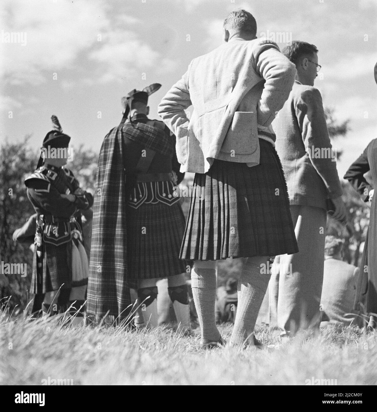Spectators in kilts at the Highland Games, a century