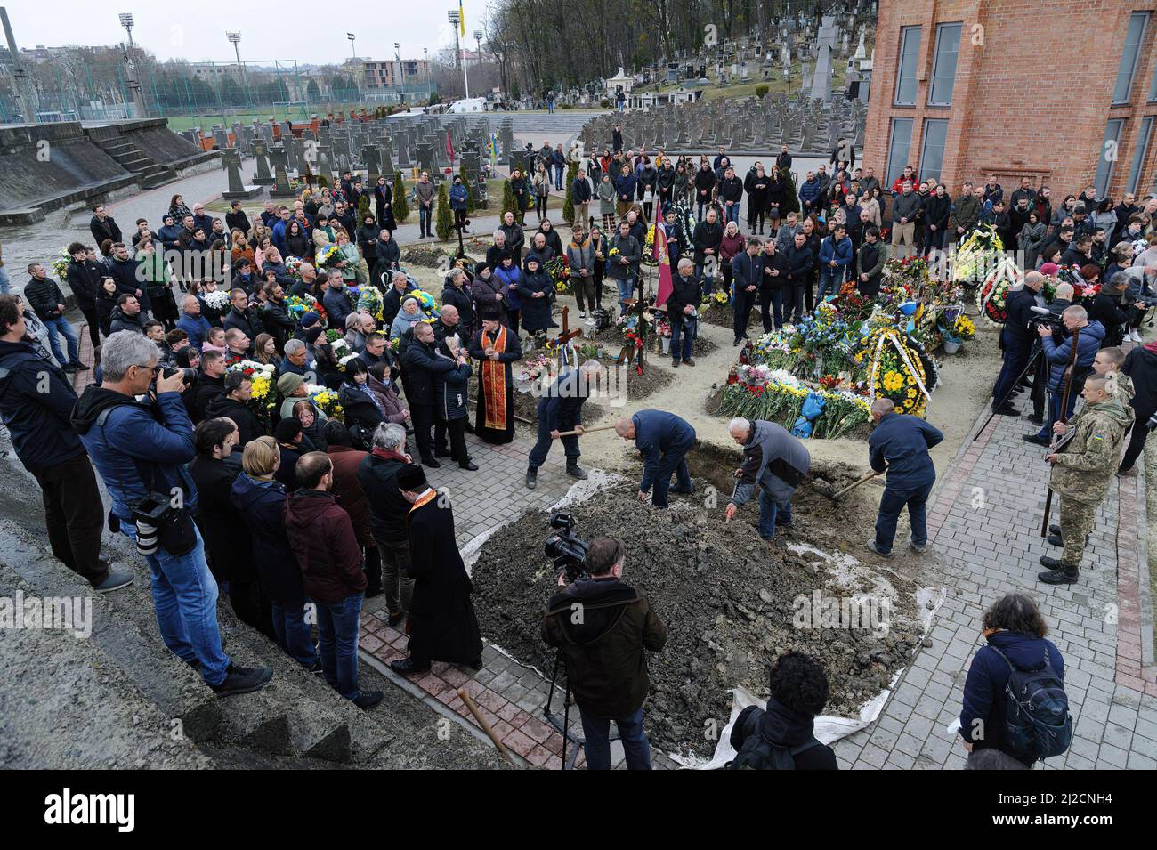 Lviv, Ukraine. 31st Mar, 2022. People seen covering the grave during the burial. Funeral ceremony of 3 Ukrainian soldiers Kozachenko Andriy, Sarkisyan Ihor, Oliynyk Yuriy killed by Russian forces amid the Russian invasion in Lviv. (Photo by Mykola Tys/SOPA Images/Sipa USA) Credit: Sipa USA/Alamy Live News Stock Photo
