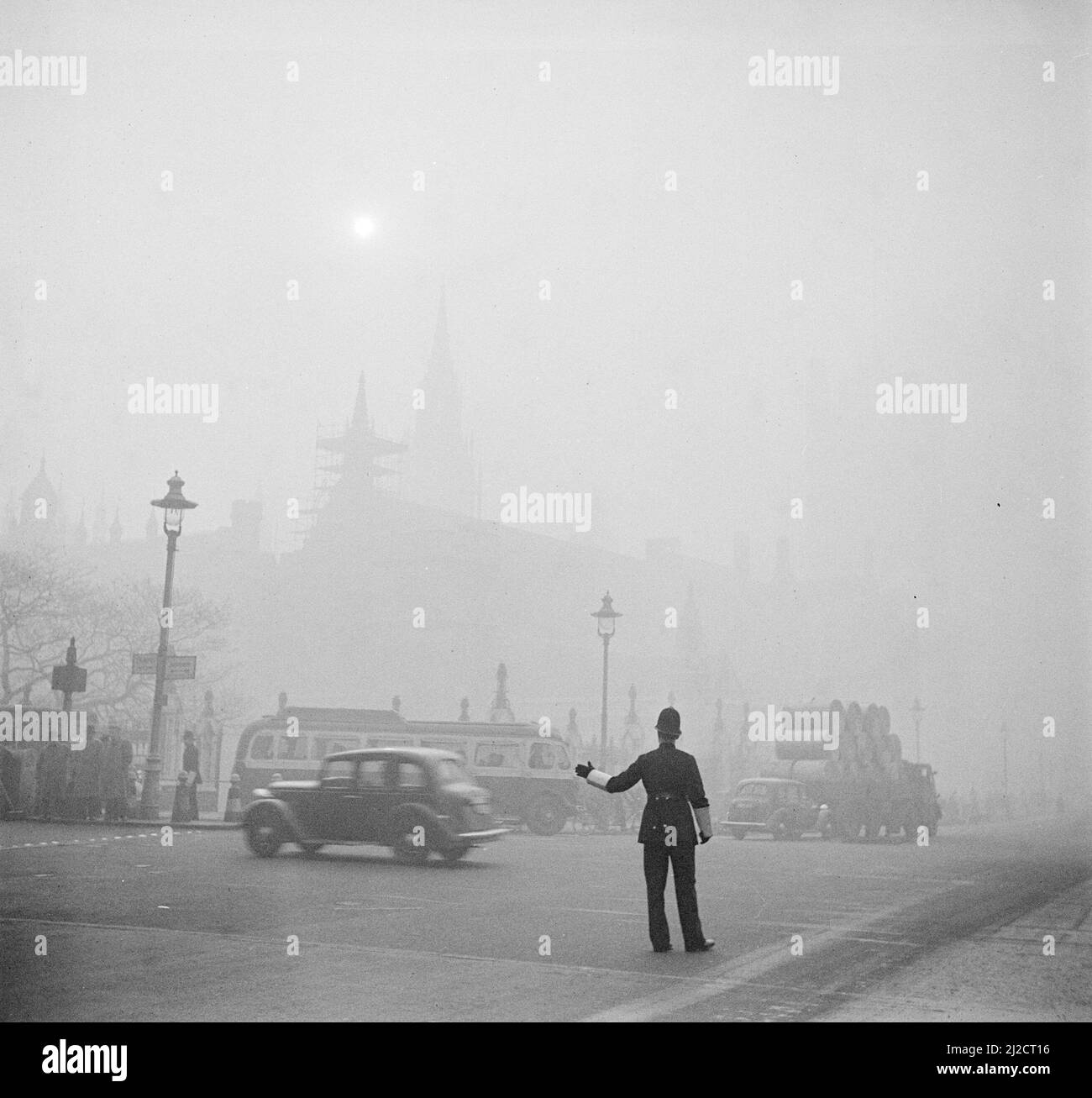 An agent controls the traffic in the mist ca: 1940s Stock Photo
