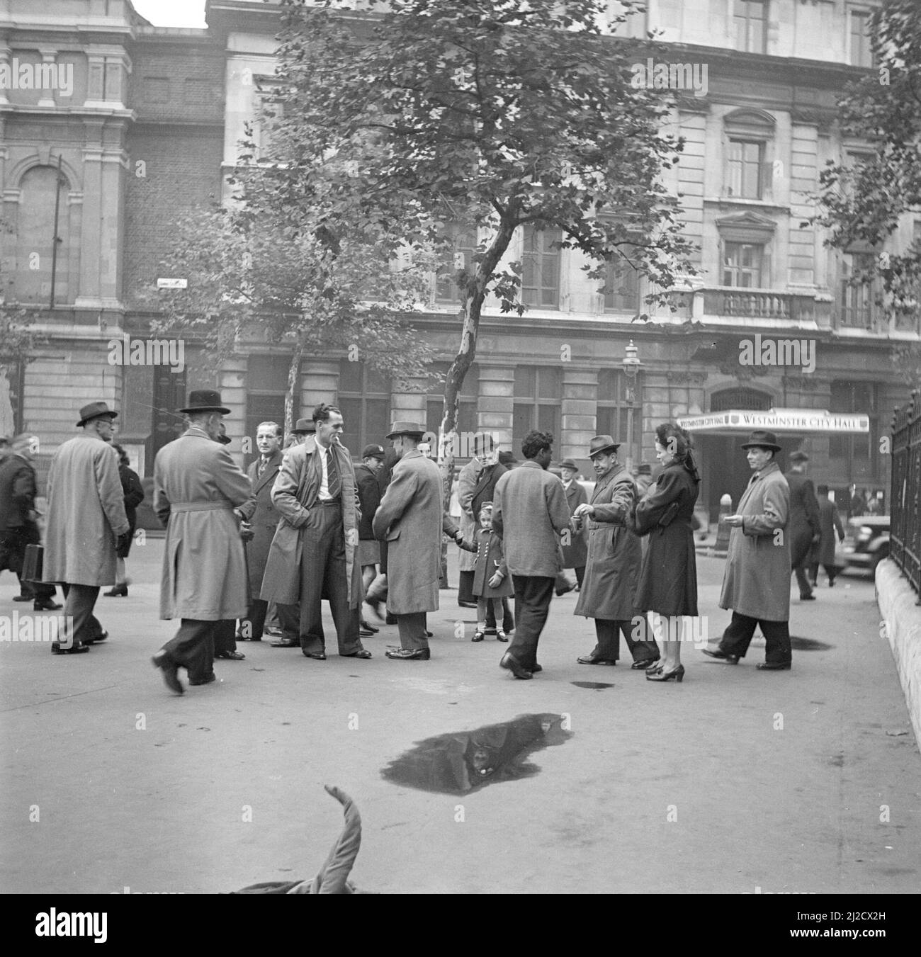 Street performer with audience in front of the Westminster City Hall  ca: 1947 Stock Photo