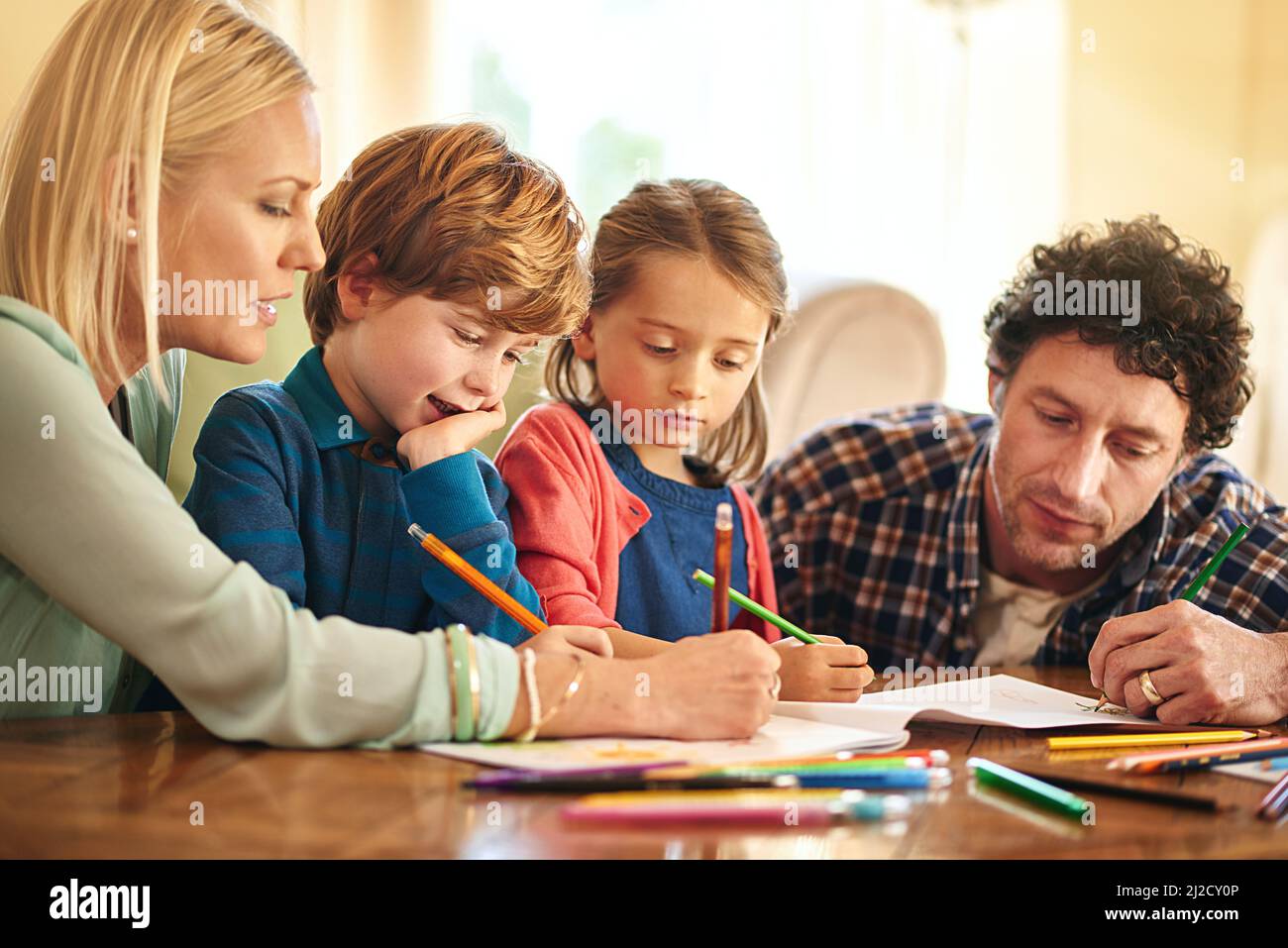Time to get creative. Cropped shot of a family drawing and colouring in pictures together at home. Stock Photo