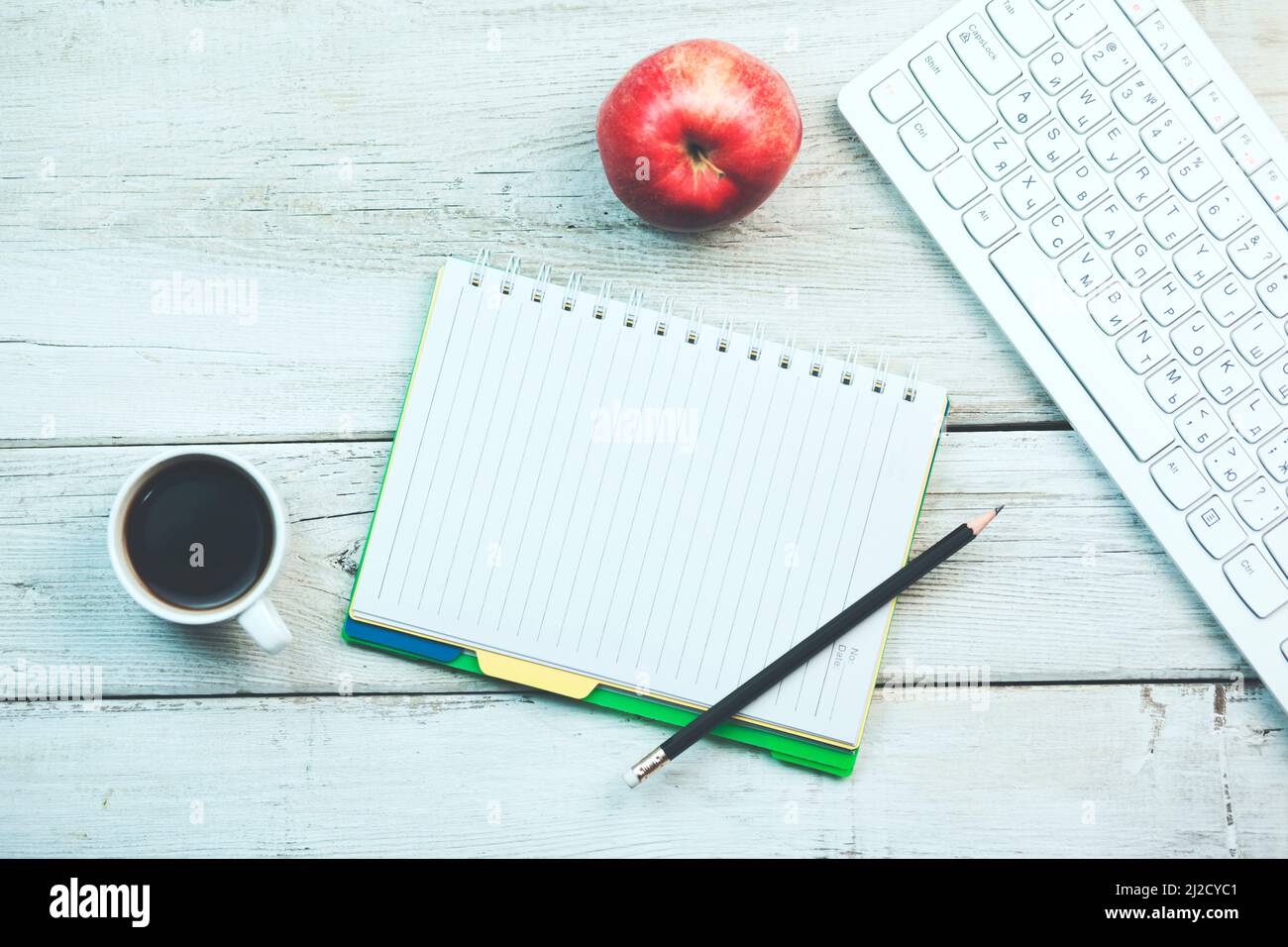 Red apple notepad and keyboard on wooden table Stock Photo - Alamy