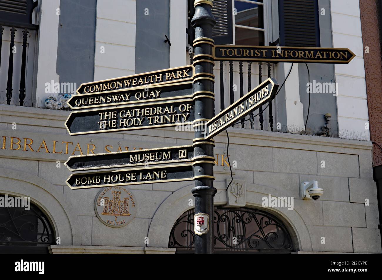 Black and gold direction signs in the main street of Gibraltar Stock