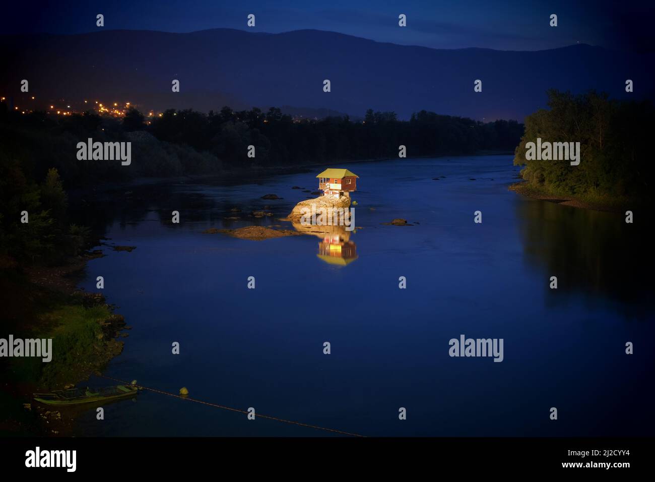 wooden house on river by night, Serbia Stock Photo