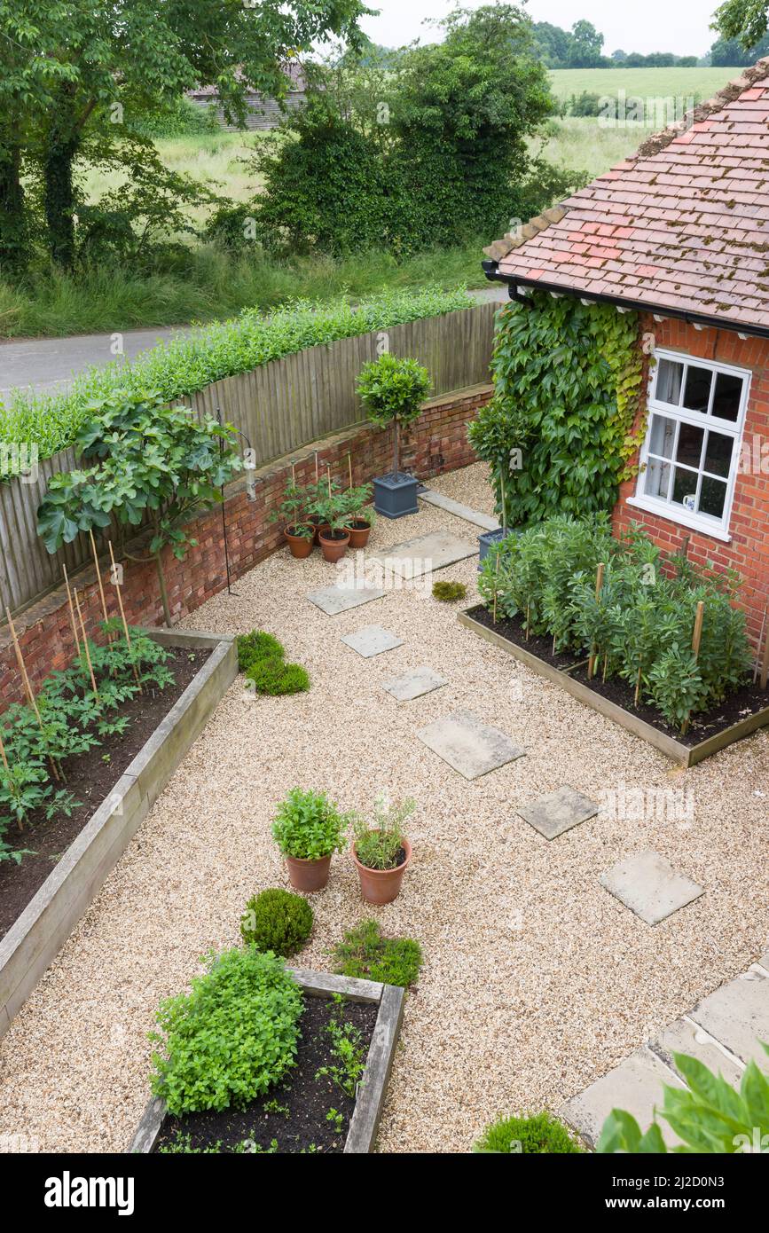 Landscaped garden with gravel, raised beds and York stone stepping stones and patio. UK garden design Stock Photo