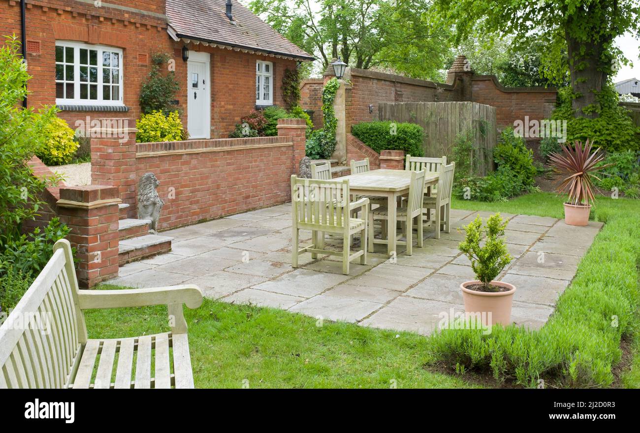 Garden patio with stone slab paving in a landscaped back garden. Large UK heritage house or country home Stock Photo