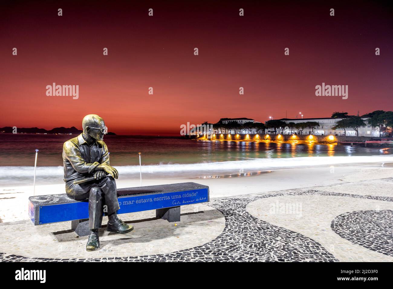 statue of poet carlos drummond de andrade in copacabana in Rio de Janeiro, Brazil - March 06, 2022: statue of poet carlos drummond de andrade with red Stock Photo