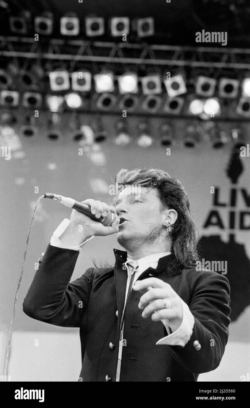 Live Aid dual venue benefit concert held on 13th July 1985 at Wembley Stadium in London, England, and the John F. Kennedy Stadium in Philadelphia, Pennsylvania, United States. The concerts were organised as a follow up to the Band Aid single 'Do They Know Its Christmas?'  to raise money for victims of the famine in Ethiopia. Picture shows  U2 lead singer Bono performing on stage during the concert at Wembley. Stock Photo