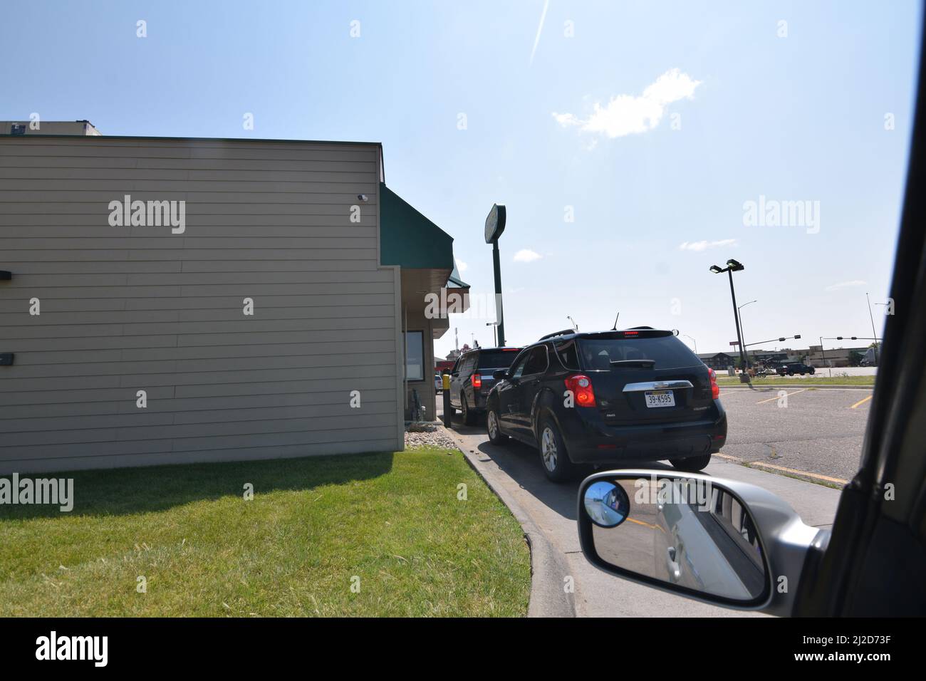 Cars waiting in line at a Runza Restaurant drive-thru in Sidney, Nebraska - August 2021 Stock Photo