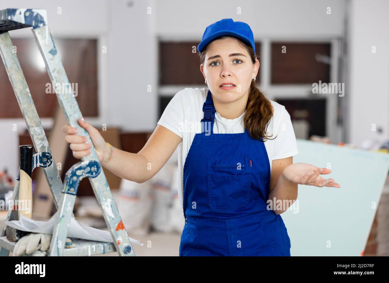 Sad woman builder standing in construction site Stock Photo