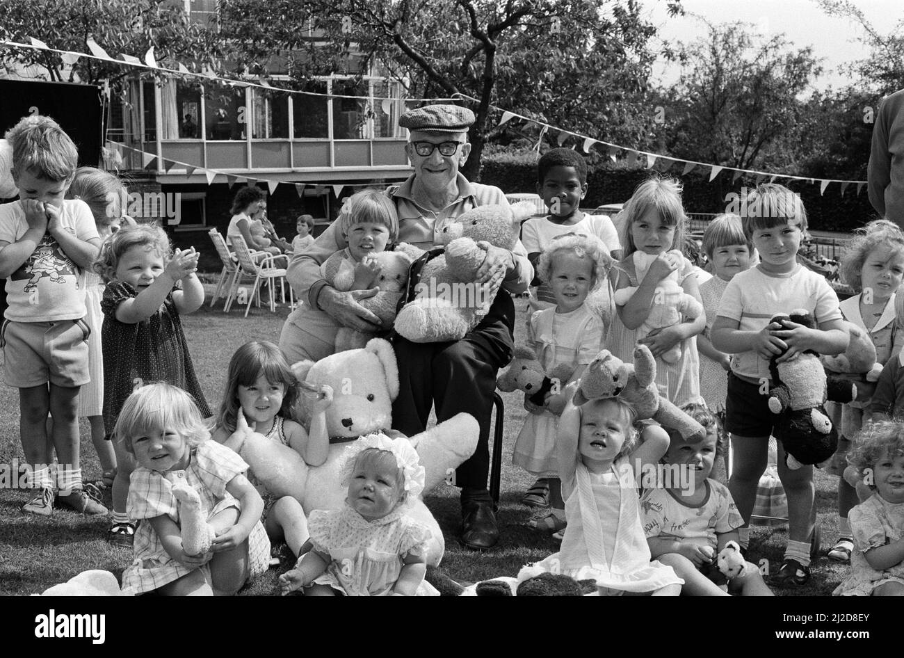 This cheerful group of toddlers from Quarry Hill playgroup found a new friend in Mr George Sykes, a resident of The Homestead, Almondbury. The group held a Teddy bears picnic with games and a Punch and Judy show at The Homestead, which is to close shortly for renovation. 16th July 1986. Stock Photo