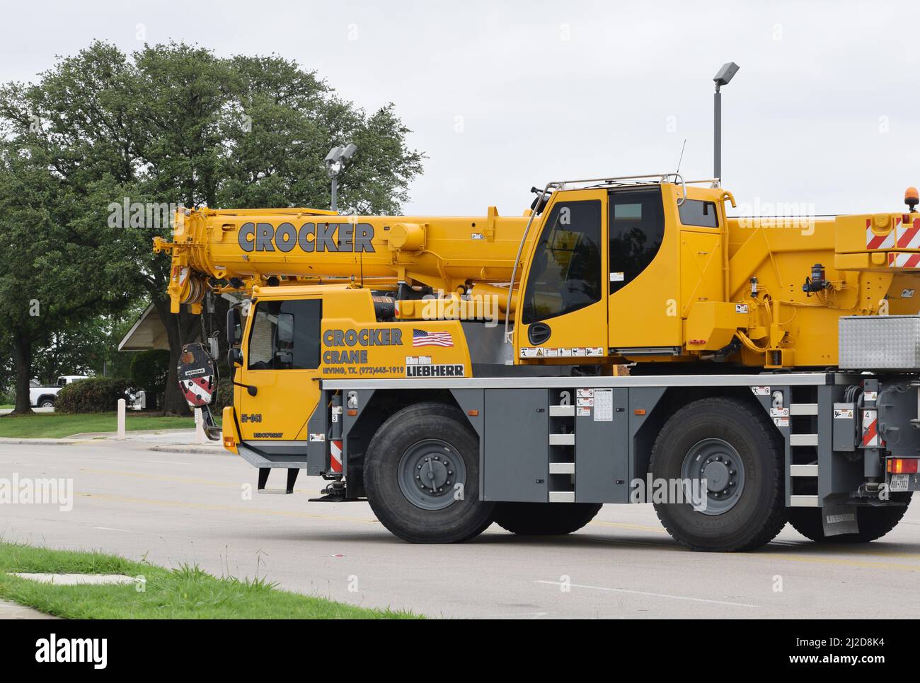 A Liebherr brand mobile crane driving on Story Rd. from Crocker Crane / RCD Equipment in Irving, TX Stock Photo