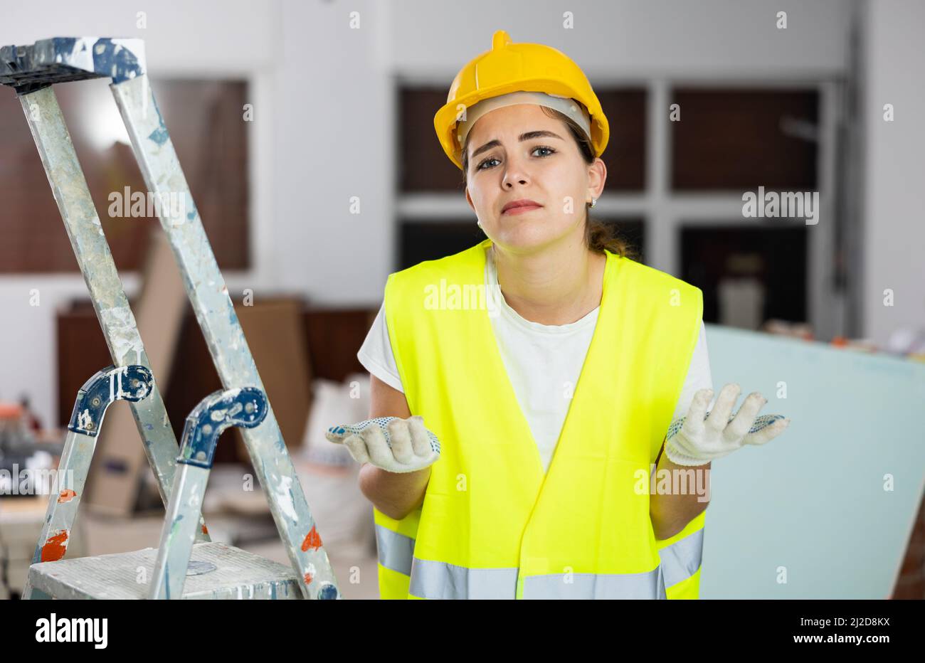 Sad woman builder standing in construction site Stock Photo