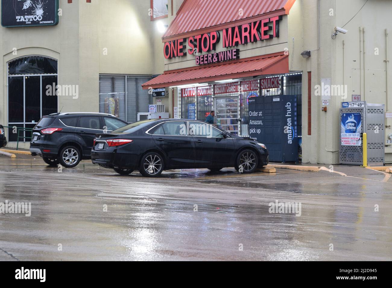 Man entering the One Stop Market convenience store on a rainy day in Irvng, TX Stock Photo