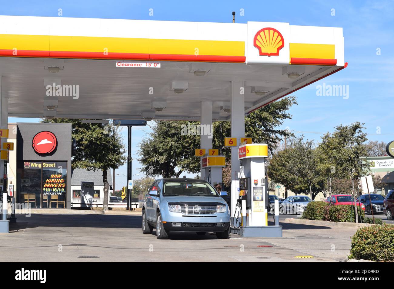 Customer pumping gas at a Shell gas station in Dallas, TX Stock Photo