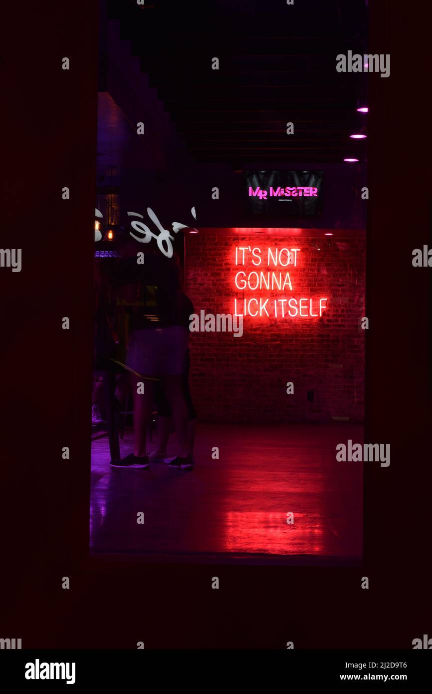 Interior of a LGBT+ bar in the Oak Lawn area of Dallas TX with a neon sign which reads, 'It's Not Gonna Lick Itself.' Stock Photo