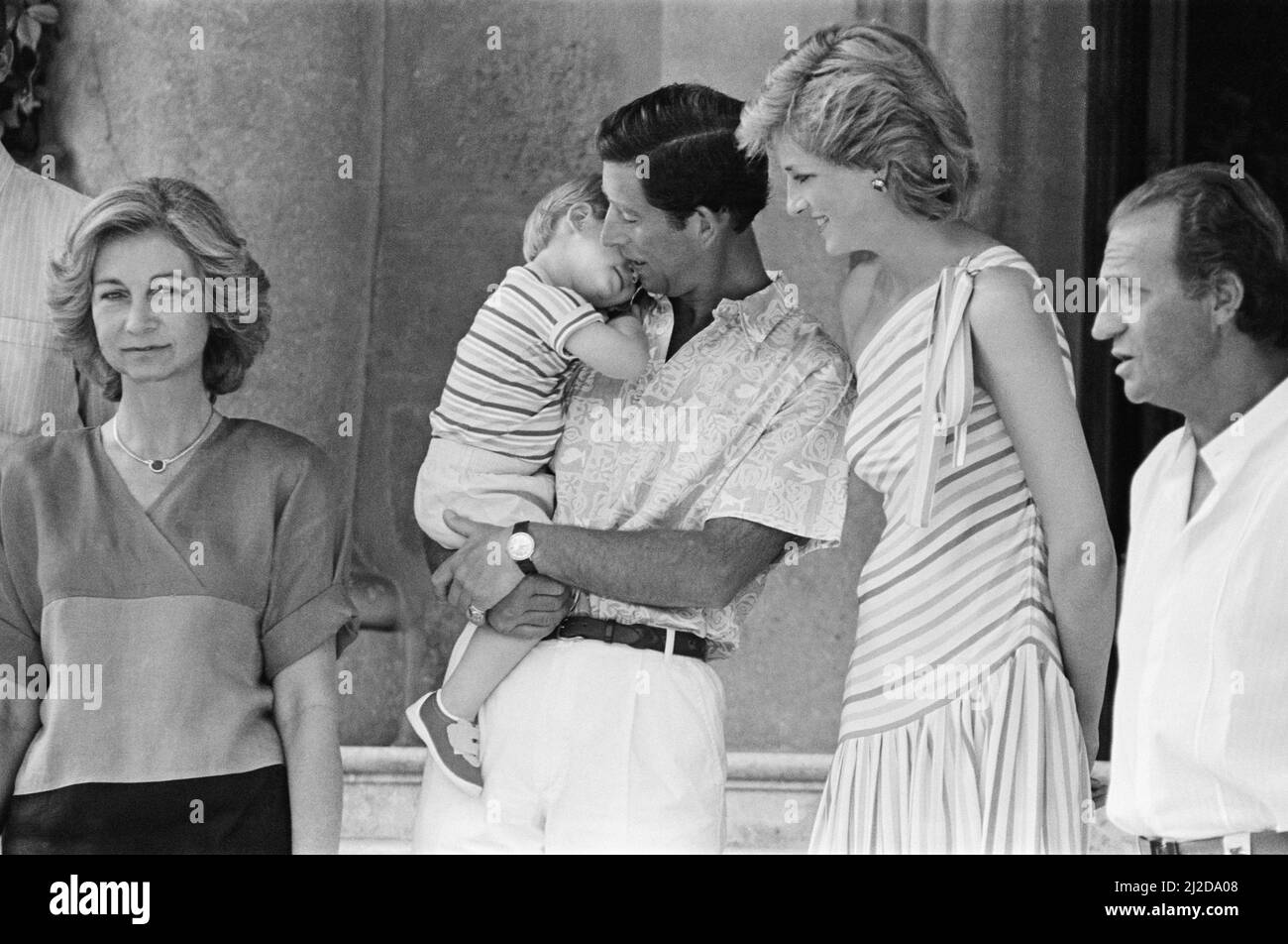HRH Princess Diana, The Princess of Wales and her husband HRH Prince Charles, The Prince of Waleson holiday in Palma, Majorca. They are the guests of King Juan Carlos (right) and his wife Sofia (left) , and are pictured here at Marivent Palace, Palma, Majorca.  In this picture Prince Charles holds a sleepy nearly 2 year old Prince Harry. Picture taken 9th August 1986 Stock Photo