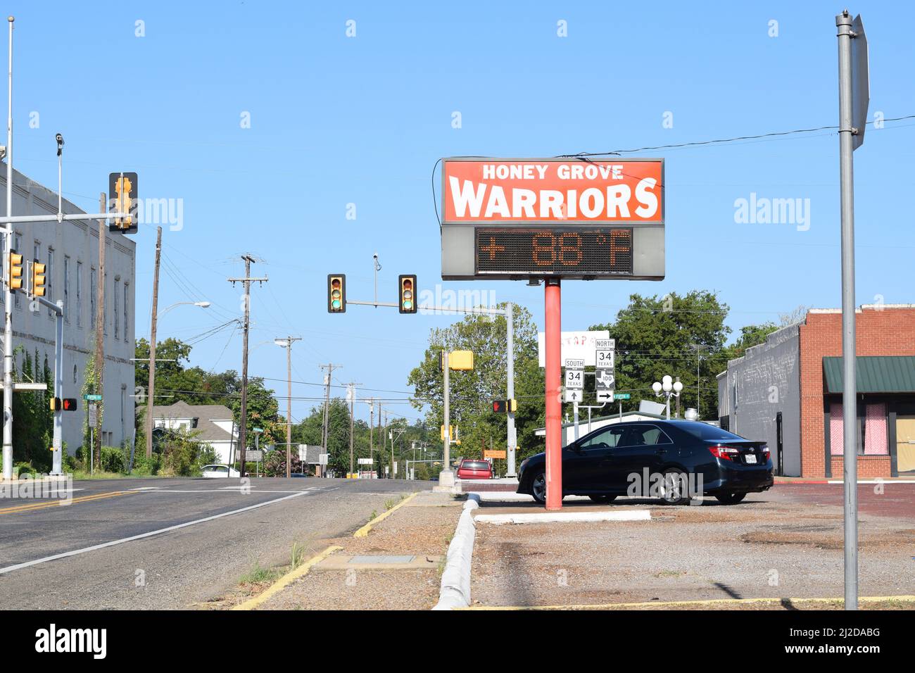 A Honey Grove Warriors sign with clock in downtown Honey Grove, TX