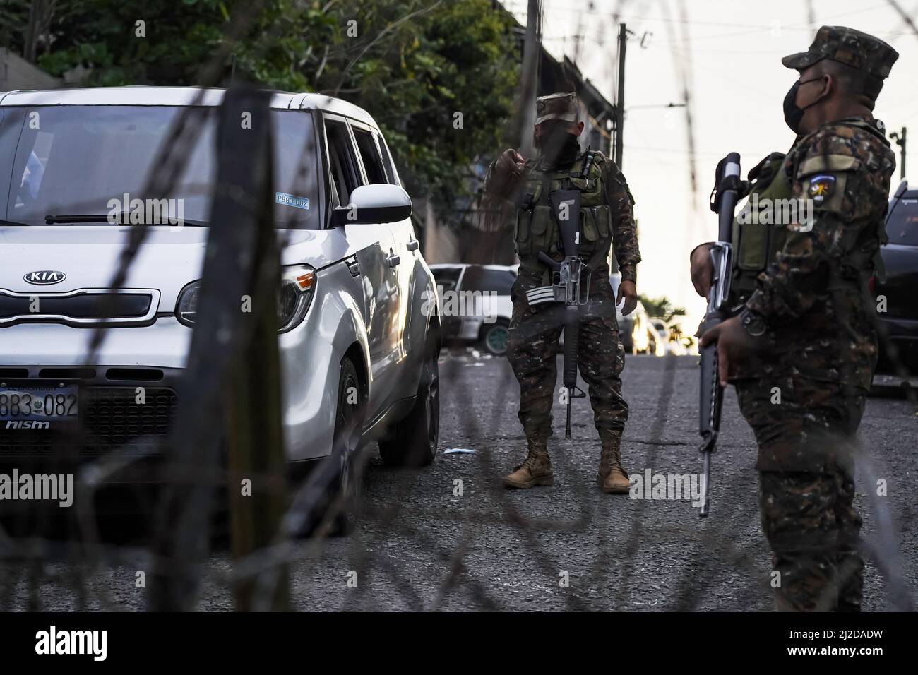 San Salvador, El Salvador. 30th Mar, 2022. A soldier guards a checkpoint at a Mara Salvatrucha MS-13 controlled community. On Sunday, March 27, the Salvadoran Congress approved a State of Emergency after the country registered its highest ever daily murder toll, with 62 homicides recorded, due to gang-related violence. According to the Salvadoran government, more than 3,000 alleged gang members from the MS-13 and Barrio 18 gangs have been detained. Credit: SOPA Images Limited/Alamy Live News Stock Photo