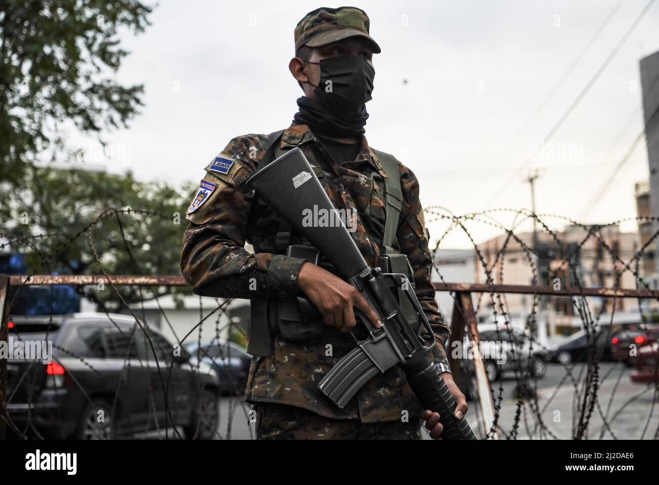 San Salvador, El Salvador. 30th Mar, 2022. A soldier guards a checkpoint at a Mara Salvatrucha MS-13 controlled community. On Sunday, March 27, the Salvadoran Congress approved a State of Emergency after the country registered its highest ever daily murder toll, with 62 homicides recorded, due to gang-related violence. According to the Salvadoran government, more than 3,000 alleged gang members from the MS-13 and Barrio 18 gangs have been detained. Credit: SOPA Images Limited/Alamy Live News Stock Photo