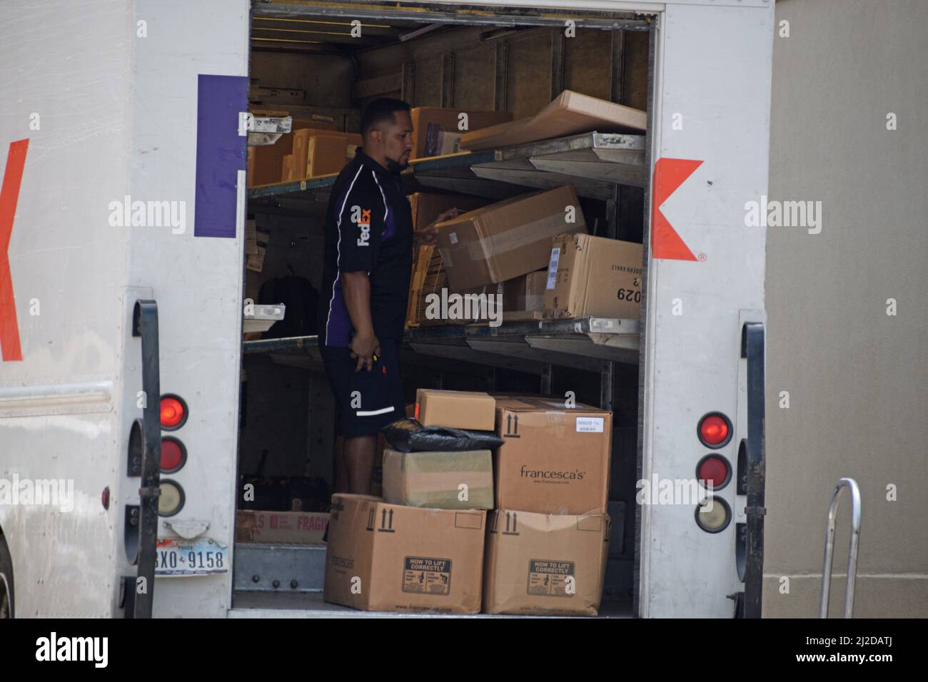 A FedEx delivery truck parked in Southlake, TX; a driver prepares to deliver packages to a business in Southlake Town Square Stock Photo