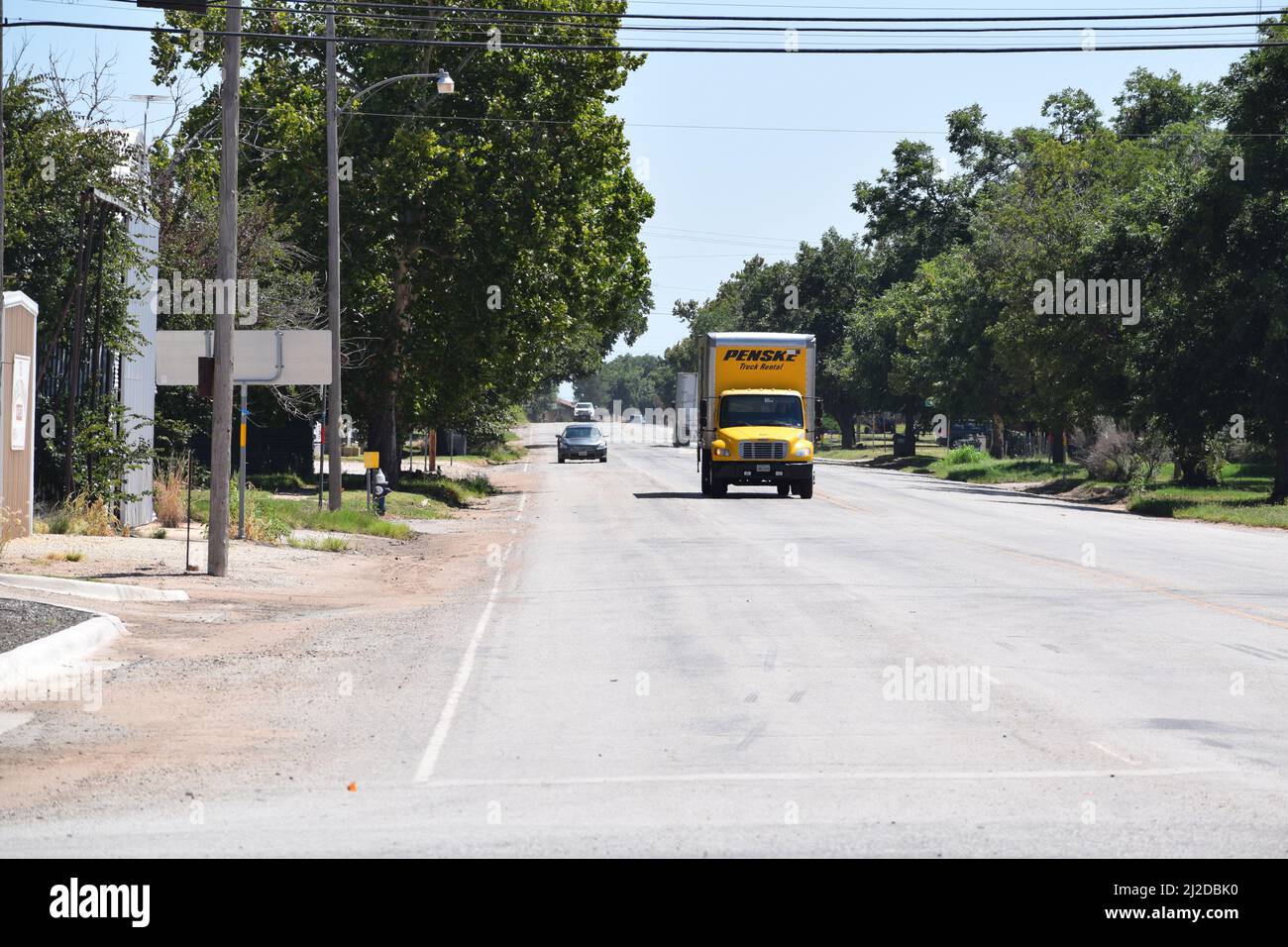 Yellow Penske Truck Rental box truck driving north through Rule Texas - August 2021 Stock Photo