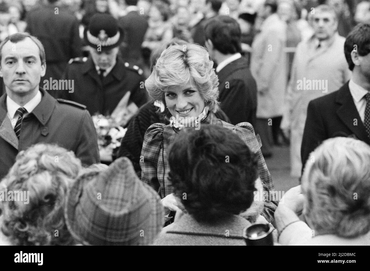The Prince and Princess of Wales visit Mid Glamorgan in Wales.On this visit, they meet the local well-wishers outside a newly electronics plant.  Picture shows Princess Diana and behind her, her bodyguard Barry Mannakee wearing a diagonal striped tie and overcoat/mac.  See other frames in this set wear Mr Mannakee has taken this coat off and is wearing a slight pin striped suit.   Picture taken 29th January 1985 Stock Photo