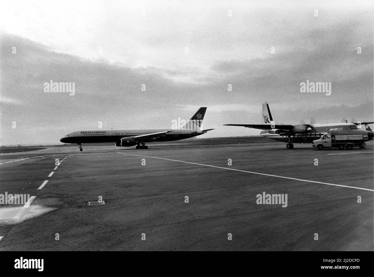 A British Airways 757 taxis past an Air UK Fokker F27 at Heathrow Airport.   17/11/1986 Stock Photo
