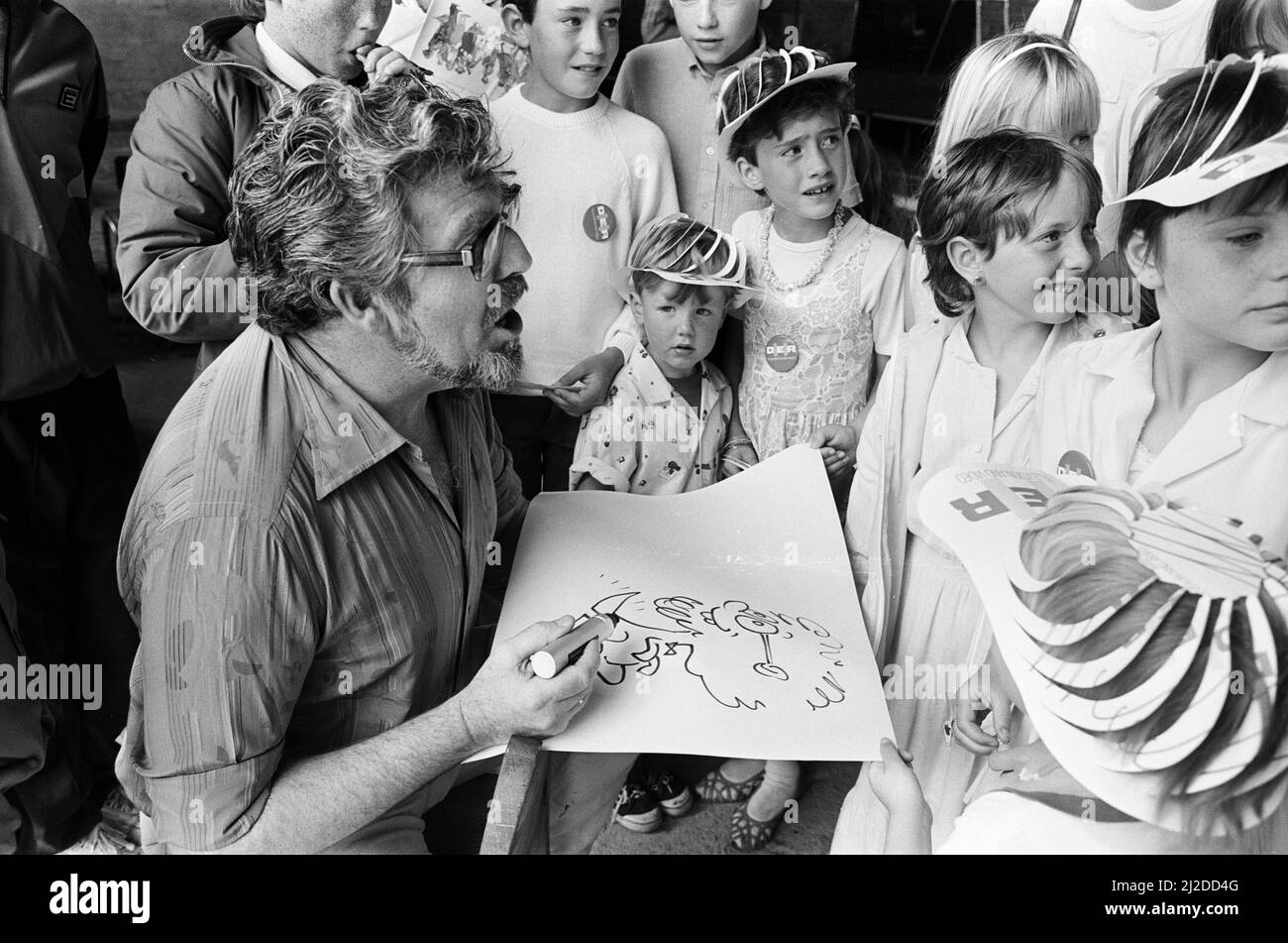 Rolf Harris, drawing sketches as he entertains children at Albert Dock, Liverpool, 13th July 1986. Stock Photo