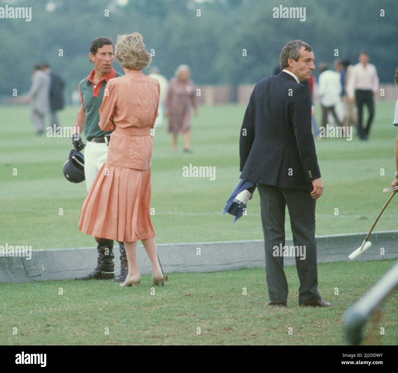HRH Princess Diana, The Princess of Wales, and HRH Prince Charles, The Prince of Wales, at Guards Polo at Windsor, Berkshire. Sanding to the behind right of the Princess, is her bodyguard Barry Mannakee, wearing the dark suit and holding a bottle of drink  Picture taken 20th June 1985 Stock Photo