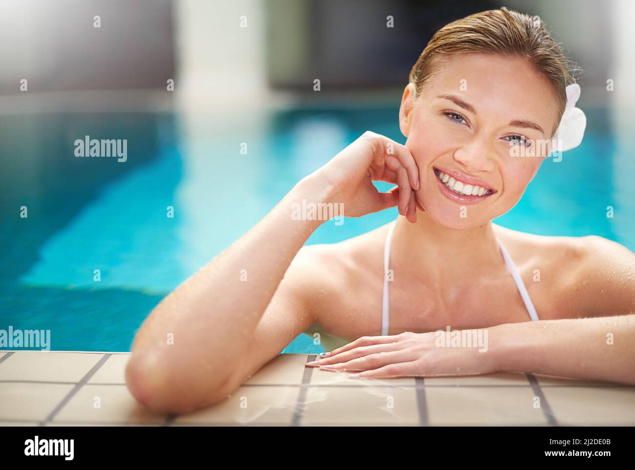Summers here and life is good. Shot of a young woman relaxing in the pool at a spa. Stock Photo