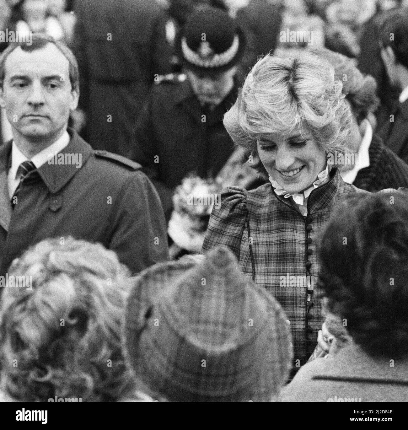 The Prince and Princess of Wales visit Mid Glamorgan in Wales.On this visit, they meet the local well-wishers outside a newly electronics plant.  Picture shows Princess Diana and behind her, her bodyguard Barry Mannakee wearing a diagonal striped tie and overcoat/mac.  See other frames in this set wear Mr Mannakee has taken this coat off and is wearing a slight pin striped suit.  Picture taken 29th January 1985 Stock Photo