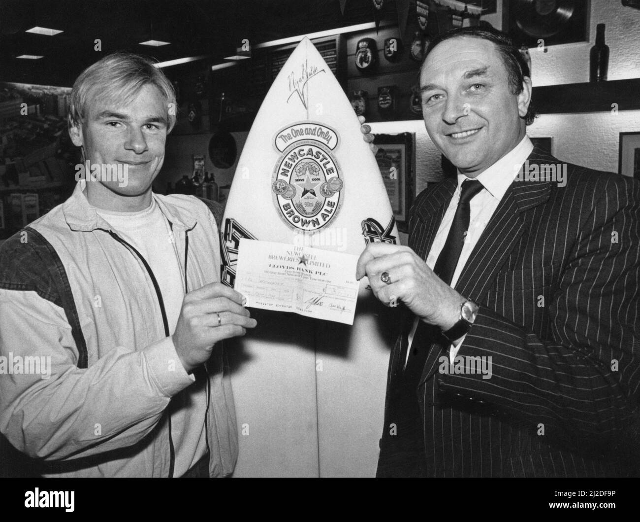 Nigel Veitch, Professional Surfer, will be making waves on the world surf circuit, thanks to sponsors Scottish and Newcastle Breweries. Nigel, 21, was presented with a cheque for 3000 pounds by Scottish and Newcastle sales director Reg Corbidge to cover his travel expenses to world contests in Los Angeles, Japan and South Africa. Pictured January 1986. Stock Photo