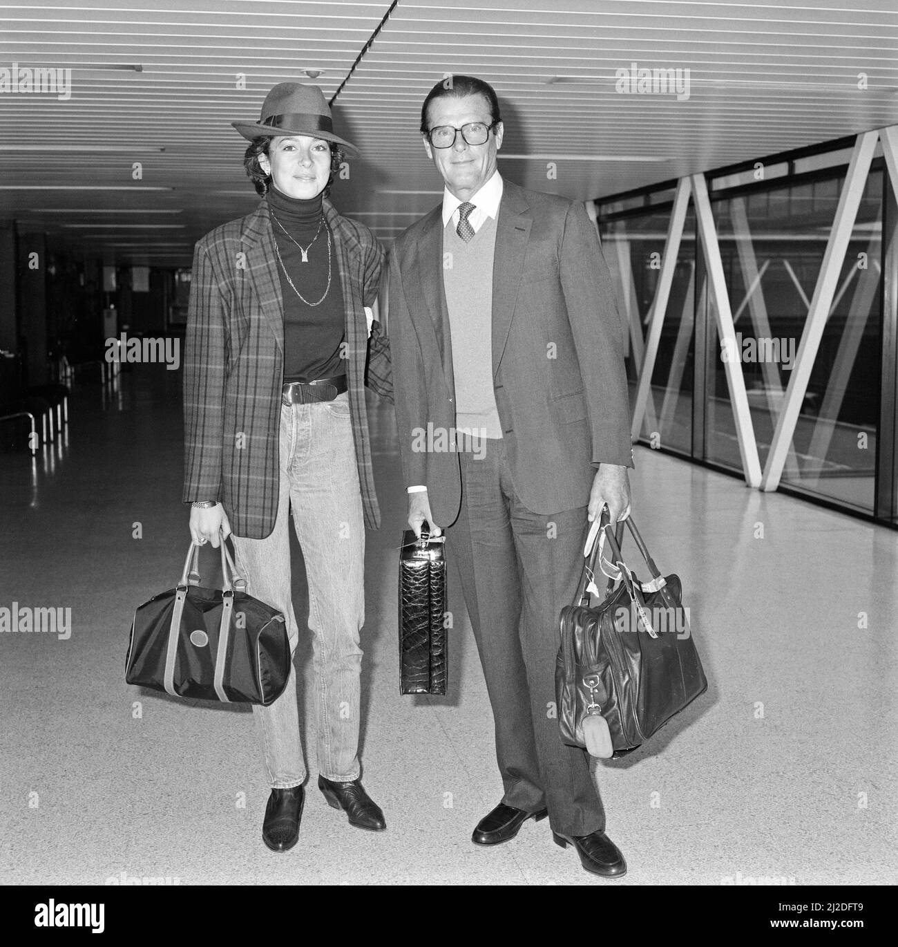 James Bond star Roger Moore turned up in another role today - as a devoted father. He flew from London to Italy with his 21-year-old daughter Deborah - she'll be appearing at a fashion show in Pisa. 18th April 1986. Stock Photo